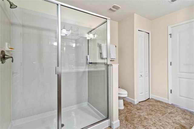 bathroom featuring baseboards, visible vents, a shower stall, tile patterned floors, and toilet