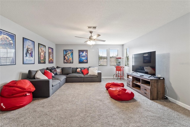 carpeted living room featuring visible vents, baseboards, a textured ceiling, and ceiling fan