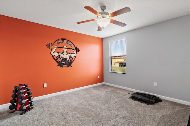 carpeted spare room with ceiling fan and baseboards