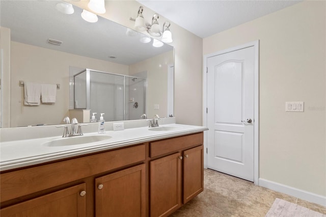 bathroom with double vanity, a stall shower, visible vents, and a sink