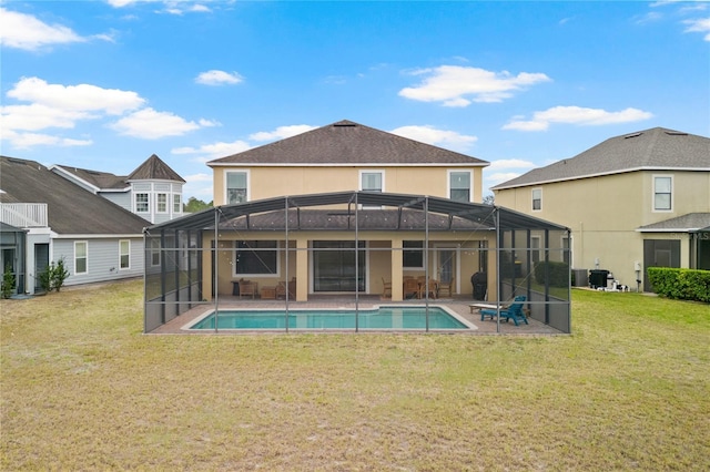 rear view of house featuring a yard, a fenced in pool, glass enclosure, and a patio area