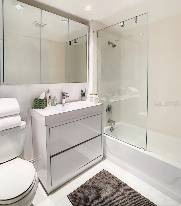 full bathroom with visible vents, shower / bathing tub combination, vanity, and toilet