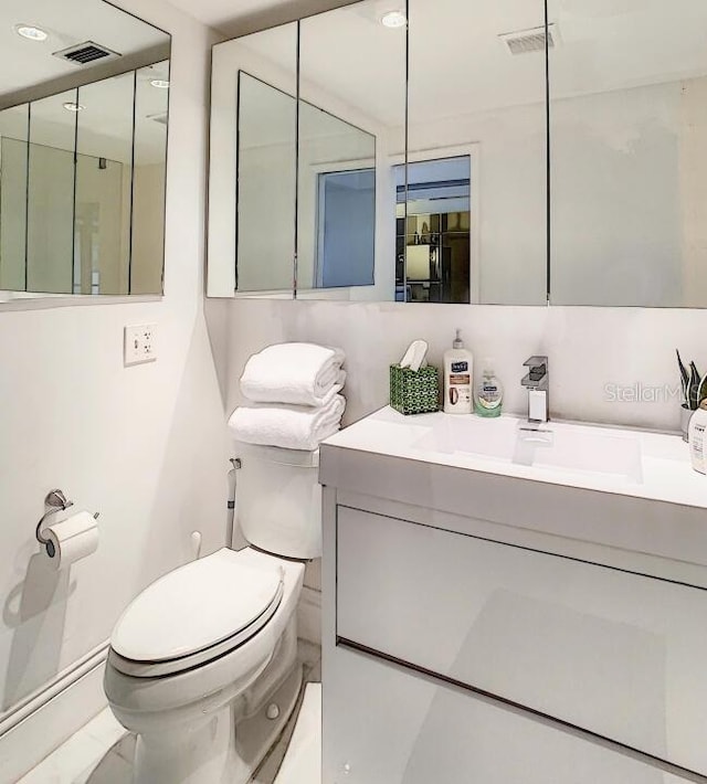 bathroom featuring toilet, visible vents, and vanity