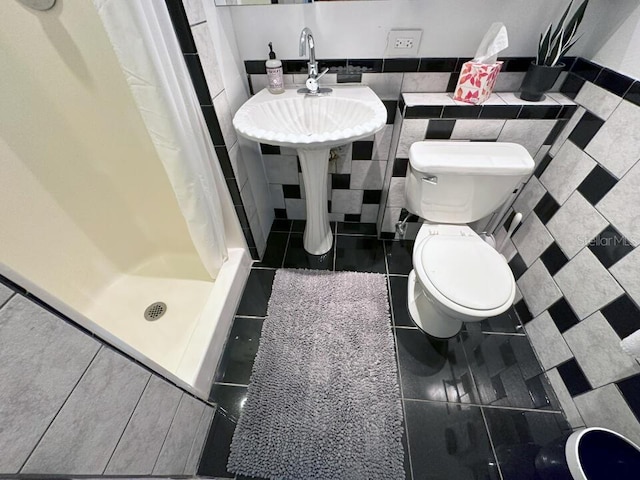 full bathroom featuring a stall shower, tile patterned flooring, and toilet