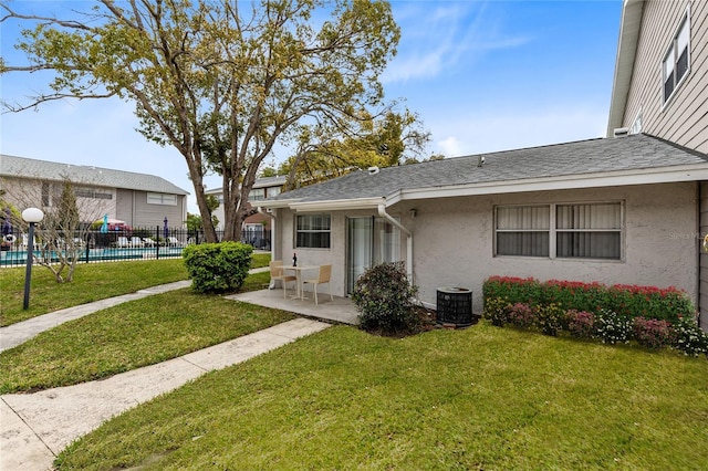 exterior space with a yard, stucco siding, a patio area, fence, and cooling unit