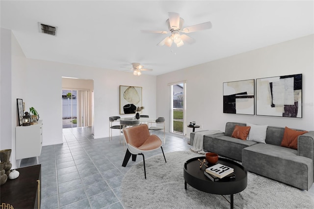 living area featuring a ceiling fan, visible vents, and tile patterned floors