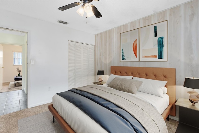 bedroom with baseboards, visible vents, ceiling fan, carpet, and a closet