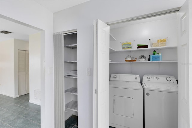 clothes washing area with laundry area, visible vents, and washer and clothes dryer