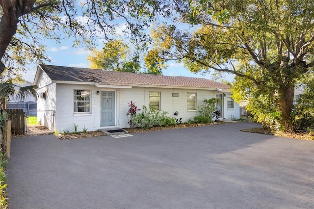 single story home featuring fence