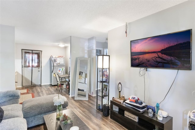 living area with a textured ceiling and wood finished floors