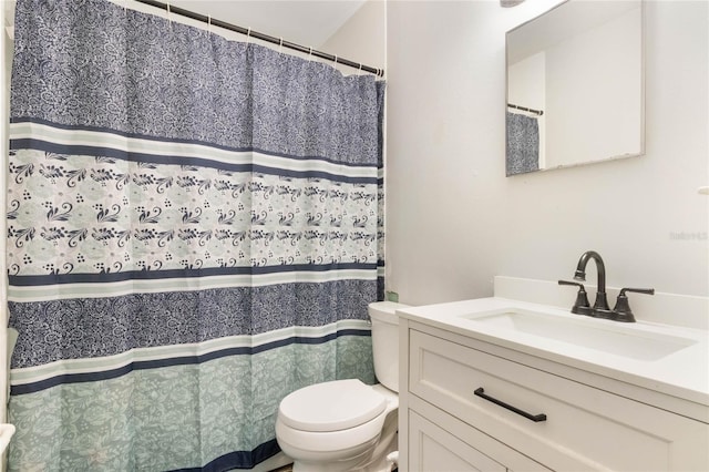 bathroom with curtained shower, vanity, and toilet