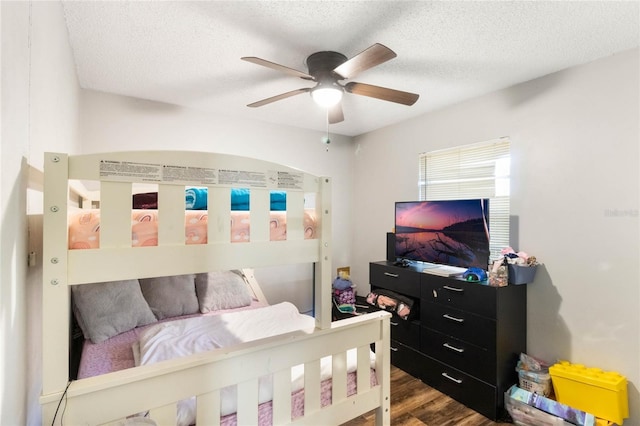 bedroom with a textured ceiling, wood finished floors, and a ceiling fan