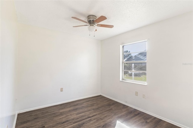 unfurnished room with dark wood-style floors, ceiling fan, a textured ceiling, and baseboards