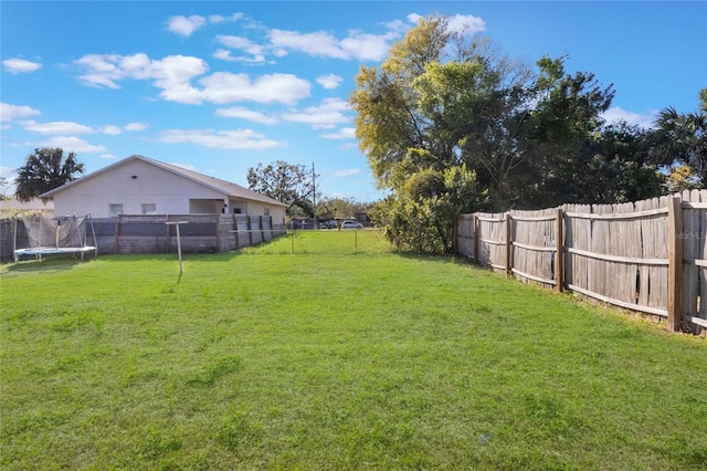 view of yard featuring a fenced backyard and a trampoline