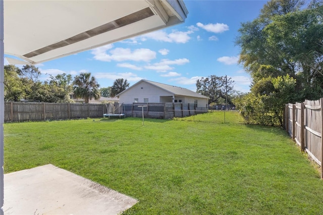 view of yard with a trampoline, a patio area, and a fenced backyard