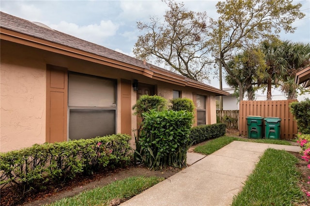 view of home's exterior with fence and stucco siding