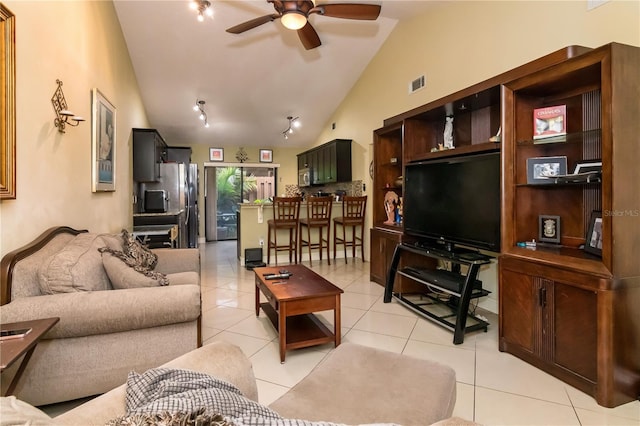 living room featuring lofted ceiling, light tile patterned floors, visible vents, and ceiling fan