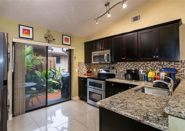 kitchen with visible vents, vaulted ceiling, light tile patterned floors, appliances with stainless steel finishes, and a sink