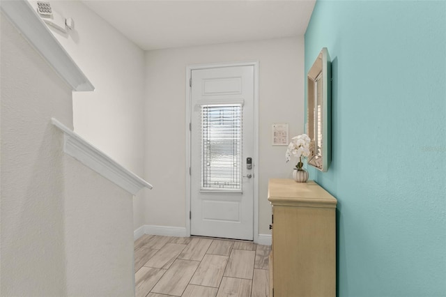 foyer entrance with wood finish floors and baseboards