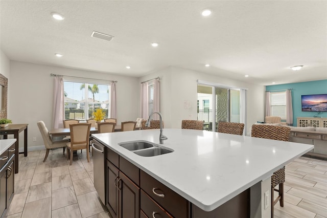 kitchen with visible vents, a sink, light countertops, dishwasher, and open floor plan