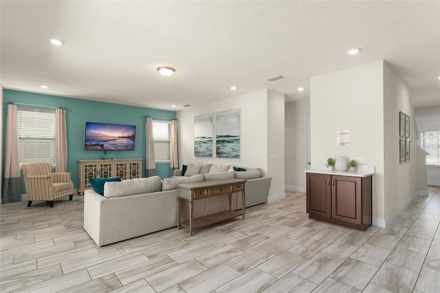 living room featuring recessed lighting, visible vents, plenty of natural light, and baseboards