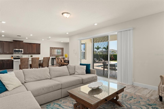 living room with recessed lighting and baseboards