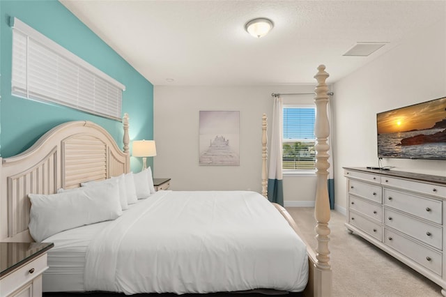 bedroom featuring baseboards, light carpet, and visible vents