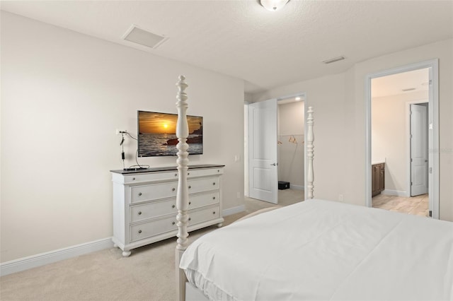 bedroom with visible vents, baseboards, and light carpet