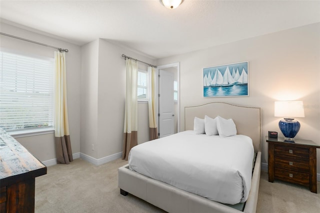 bedroom with light colored carpet and baseboards