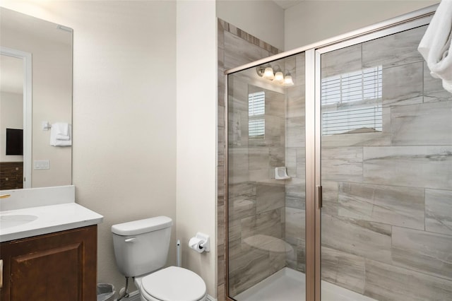 bathroom featuring toilet, a stall shower, and vanity