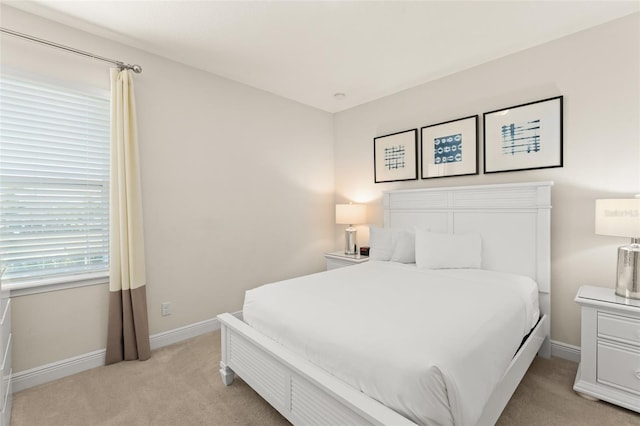 bedroom with baseboards and light carpet