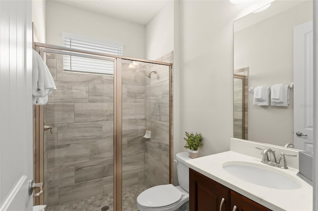 full bath featuring toilet, a stall shower, and vanity