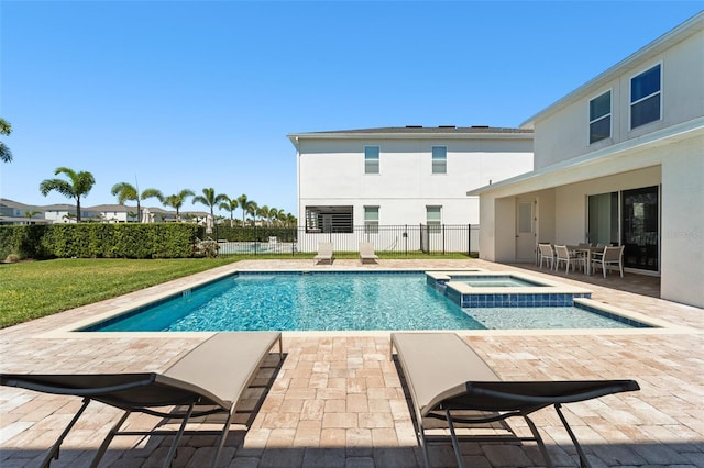 view of swimming pool featuring a patio area, a pool with connected hot tub, and fence