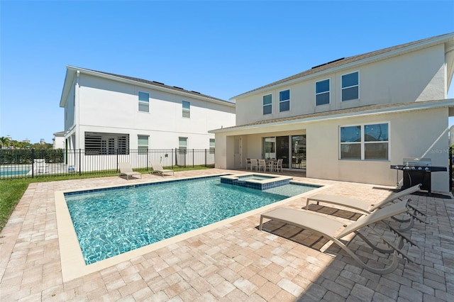 back of property featuring a patio area, stucco siding, a pool with connected hot tub, and fence