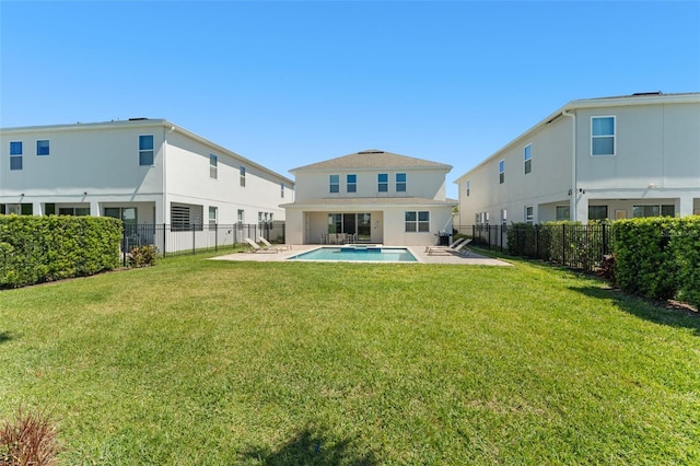 rear view of property featuring a patio area, a yard, a fenced backyard, and stucco siding