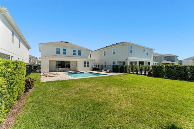 rear view of house featuring a patio, a lawn, a fenced backyard, and a pool with connected hot tub