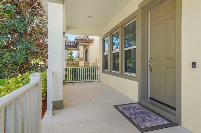 exterior space featuring covered porch, a tiled roof, and stucco siding