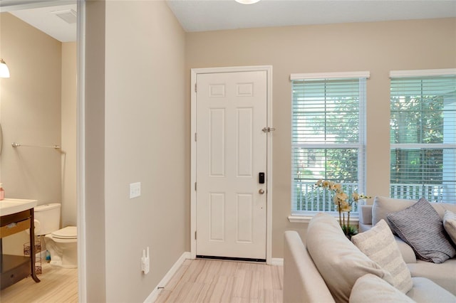 interior space featuring baseboards and light wood finished floors