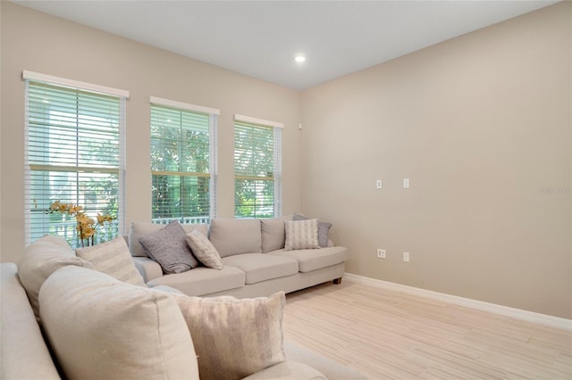 living room featuring light wood-style flooring, baseboards, and recessed lighting