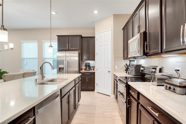 kitchen featuring decorative backsplash, stainless steel appliances, a sink, and light countertops