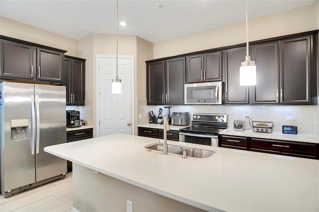 kitchen with tasteful backsplash, appliances with stainless steel finishes, and light countertops