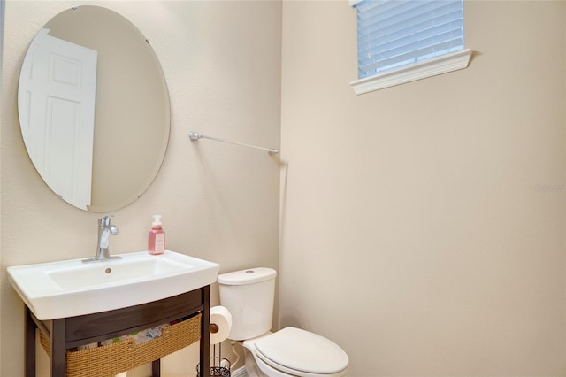 half bathroom featuring toilet and vanity