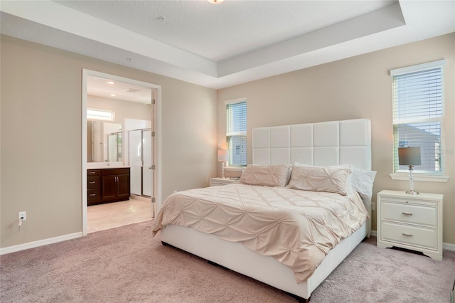 bedroom featuring light carpet, multiple windows, baseboards, and a raised ceiling