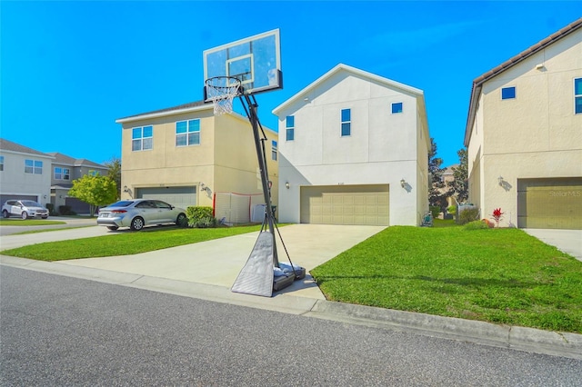 view of front of home featuring a garage, concrete driveway, a front lawn, and stucco siding