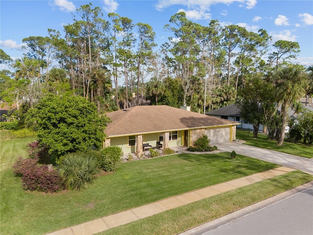 view of front facade with an attached garage, concrete driveway, a front lawn, and roof with shingles