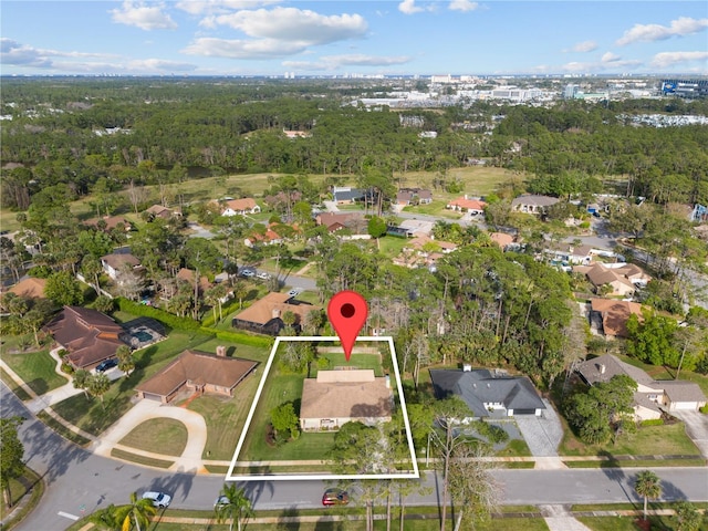 birds eye view of property featuring a residential view and a wooded view