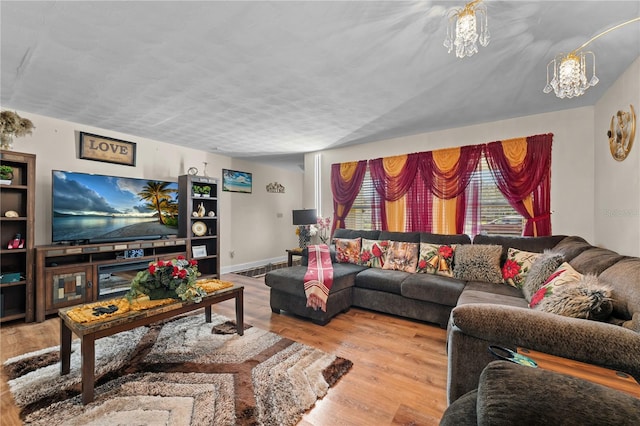 living area featuring wood finished floors, baseboards, and a chandelier