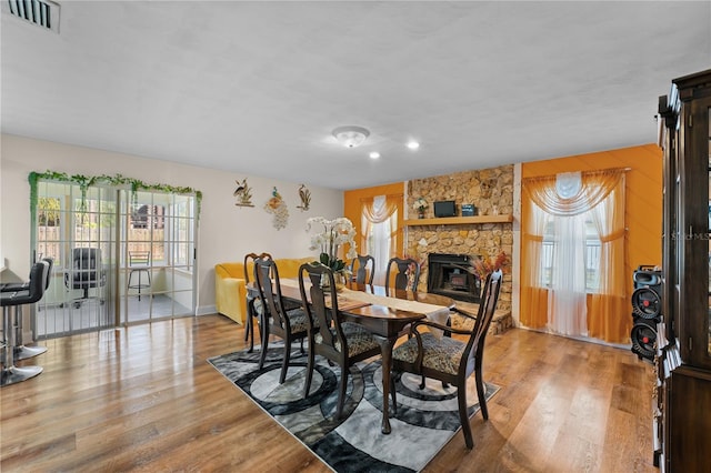 dining space with a wealth of natural light, visible vents, and wood finished floors