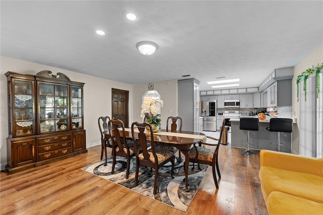 dining space featuring light wood-style flooring and recessed lighting