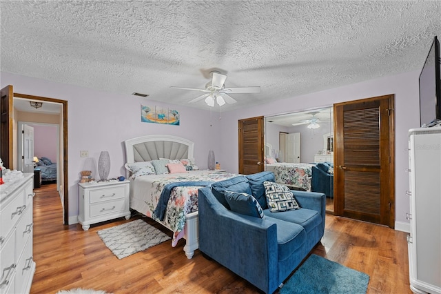 bedroom featuring visible vents, ceiling fan, baseboards, and light wood-style floors